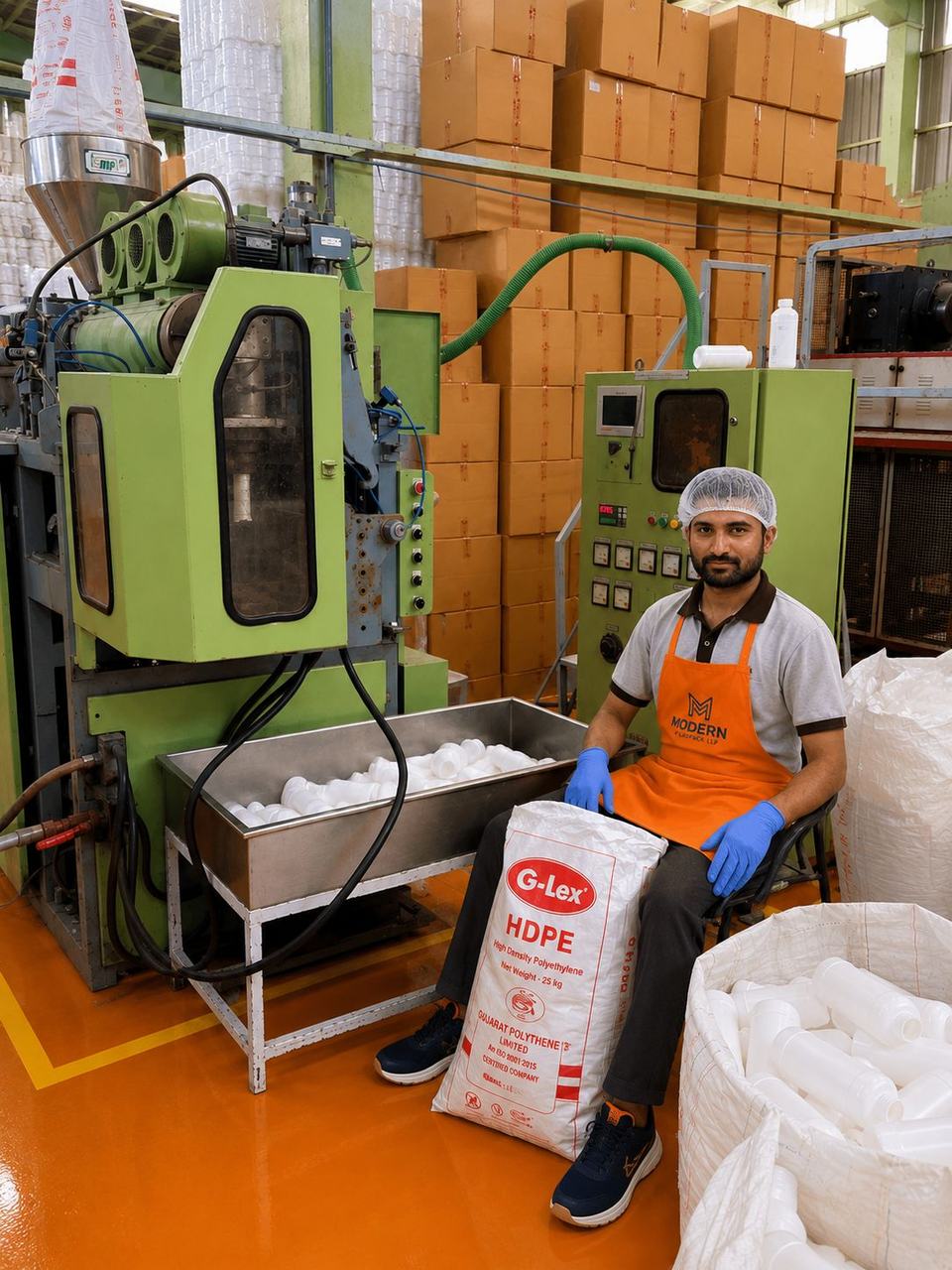Operator at an HDPE blow moulding machine with freshly moulded bottles